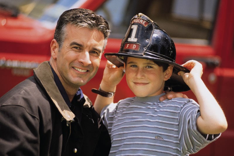 A firefighter next to a young boy