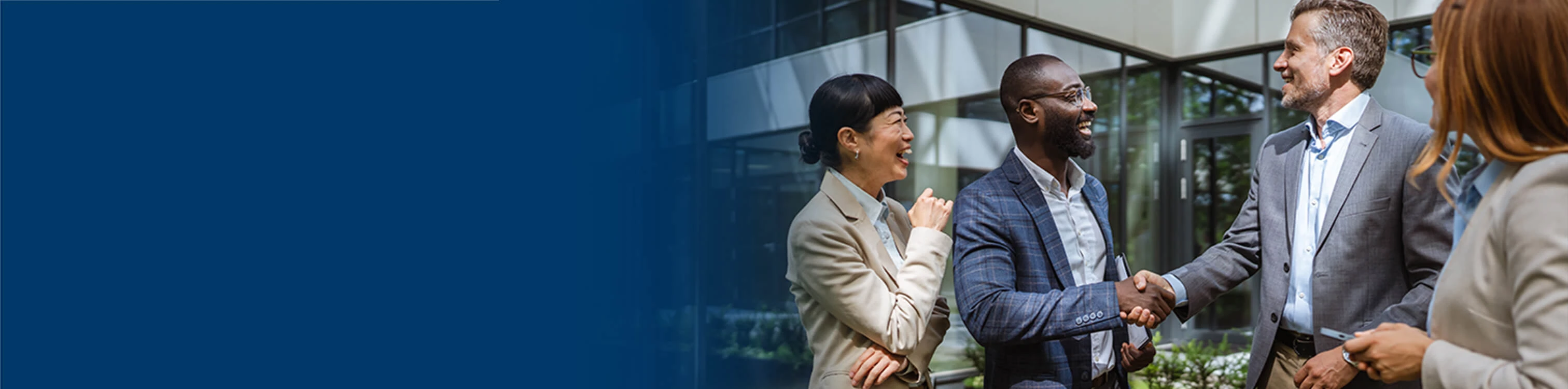 Image of two men shaking hands in a group of businesspeople