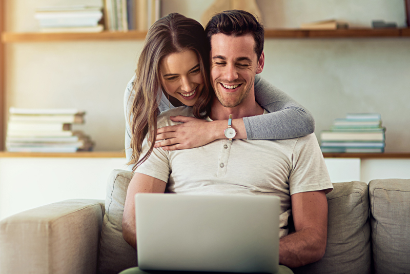 A young couple looking online for auto rates