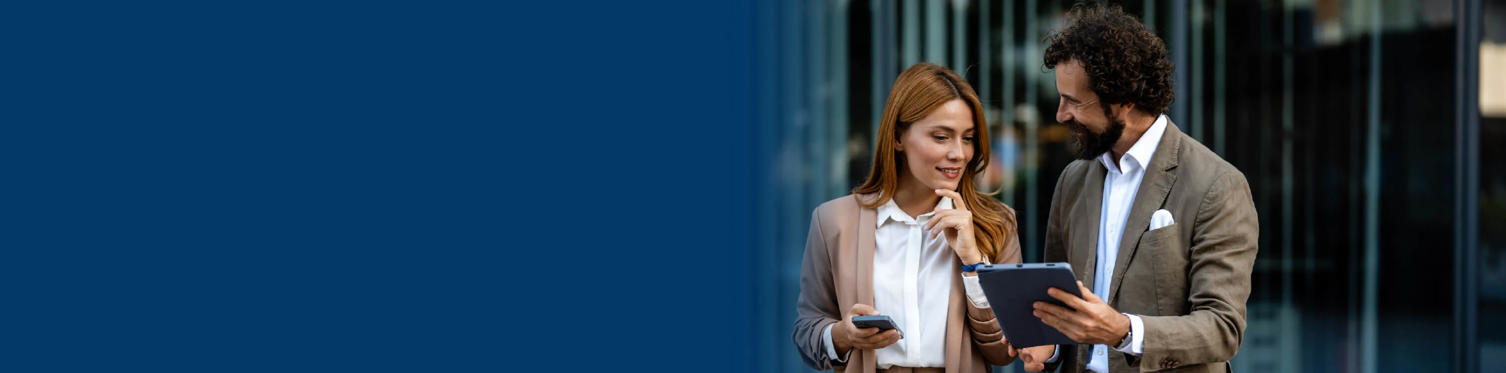 Image of two professionals talking and looking at one tablet