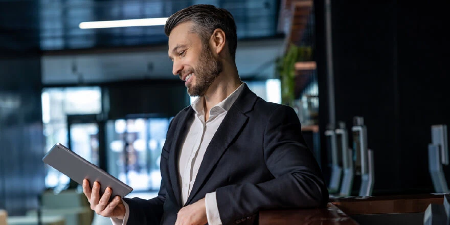 Image of a businessman in an office looking down at his tablet