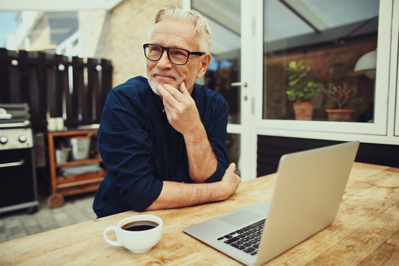 A man drinking a cup of coffee in his kitchen