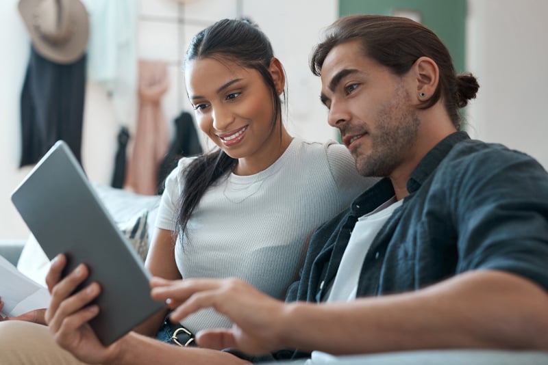 A man and woman looking at a tablet