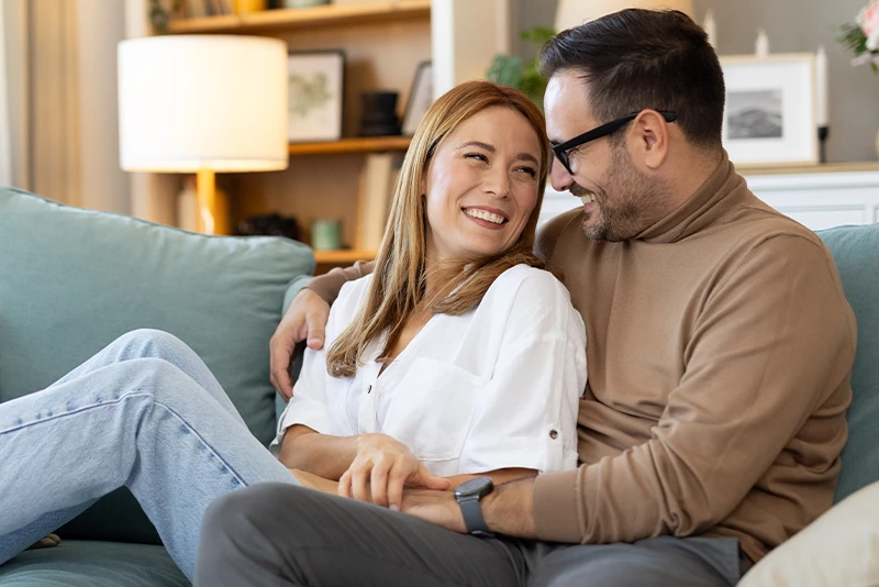 A couple sitting together on the couch