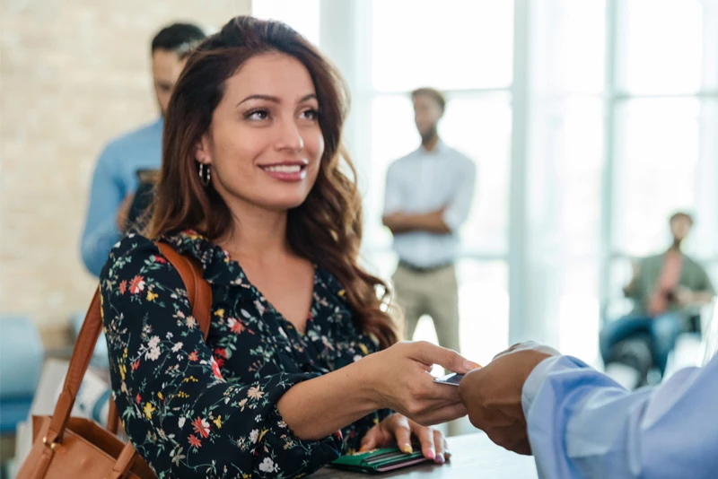 Image of a woman using her card to tap to pay