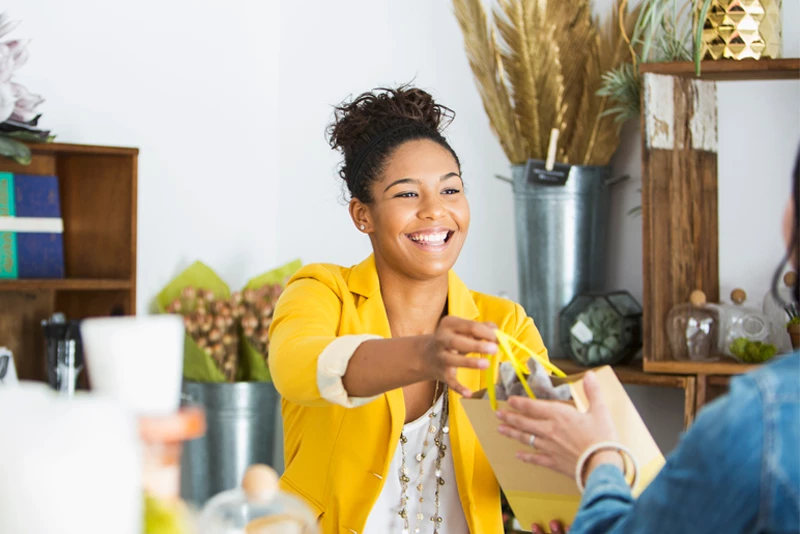 An owner handing her client her purchase