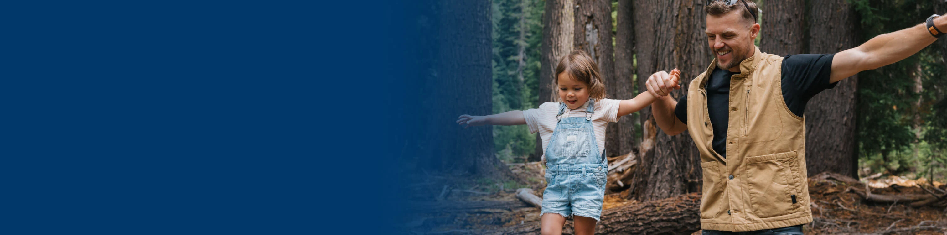 A dad and his daughter out for a walk in the woods