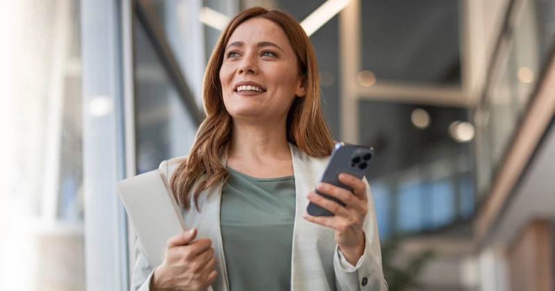 A photo of a businesswoman looking forward with her phone in her hand