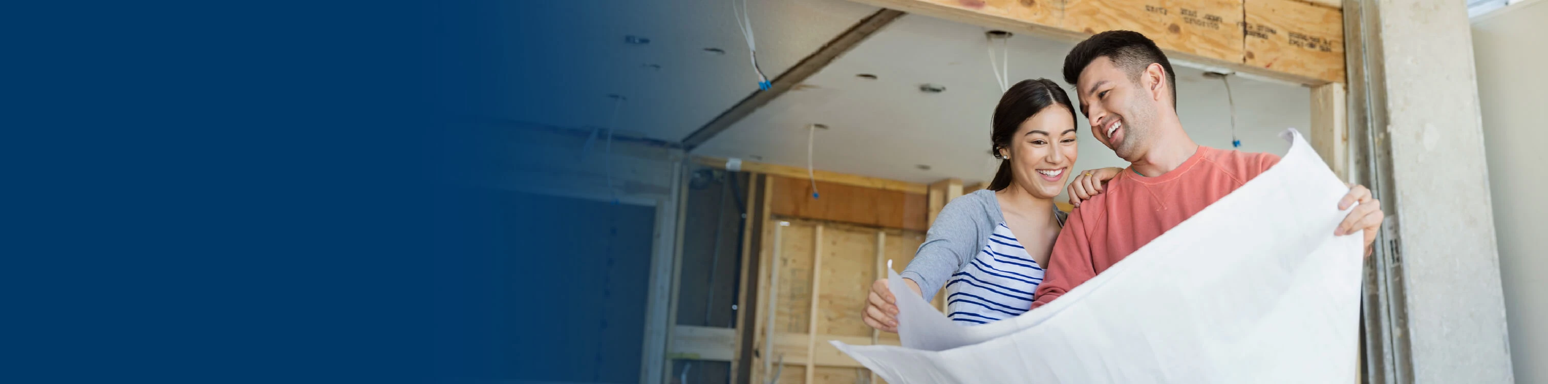 A couple looking at plans for their home renovation project