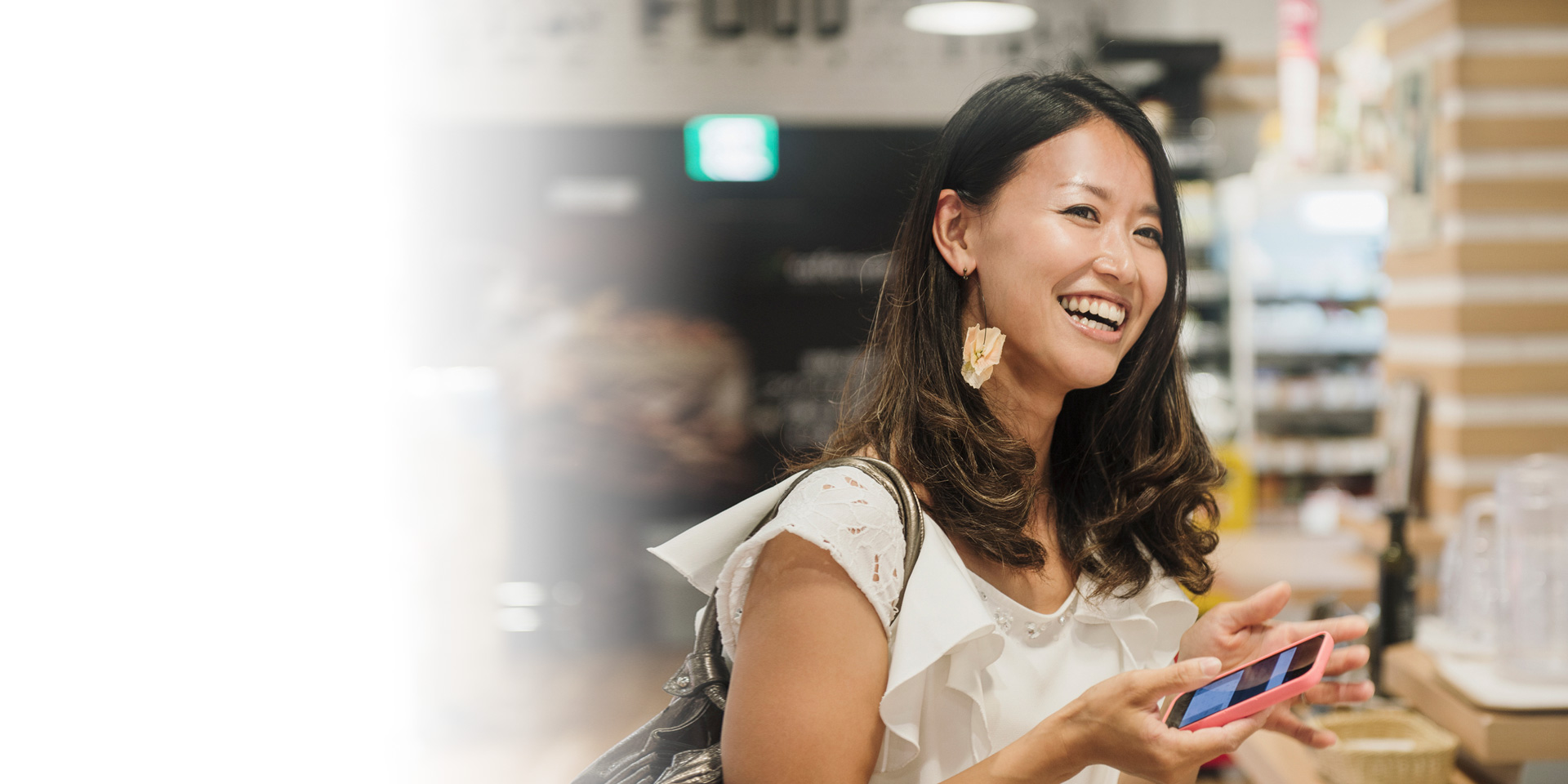 A woman smiling while holding her mobile phone