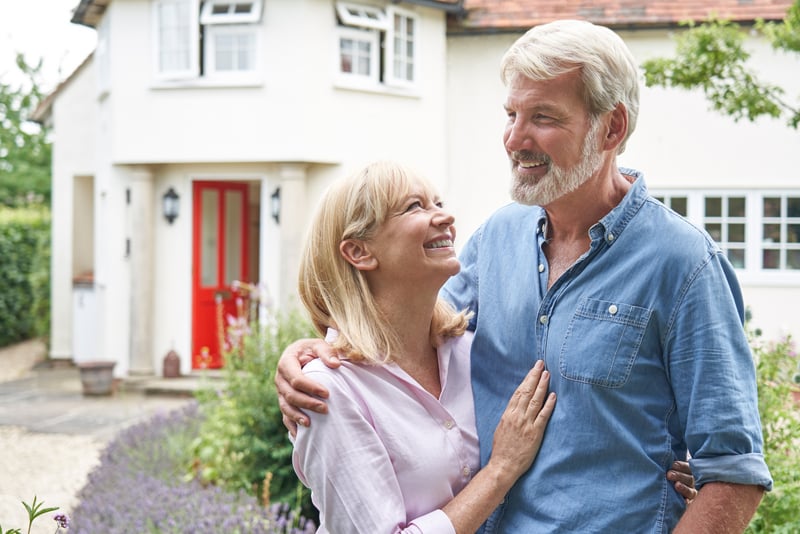 A couple standing outside their home