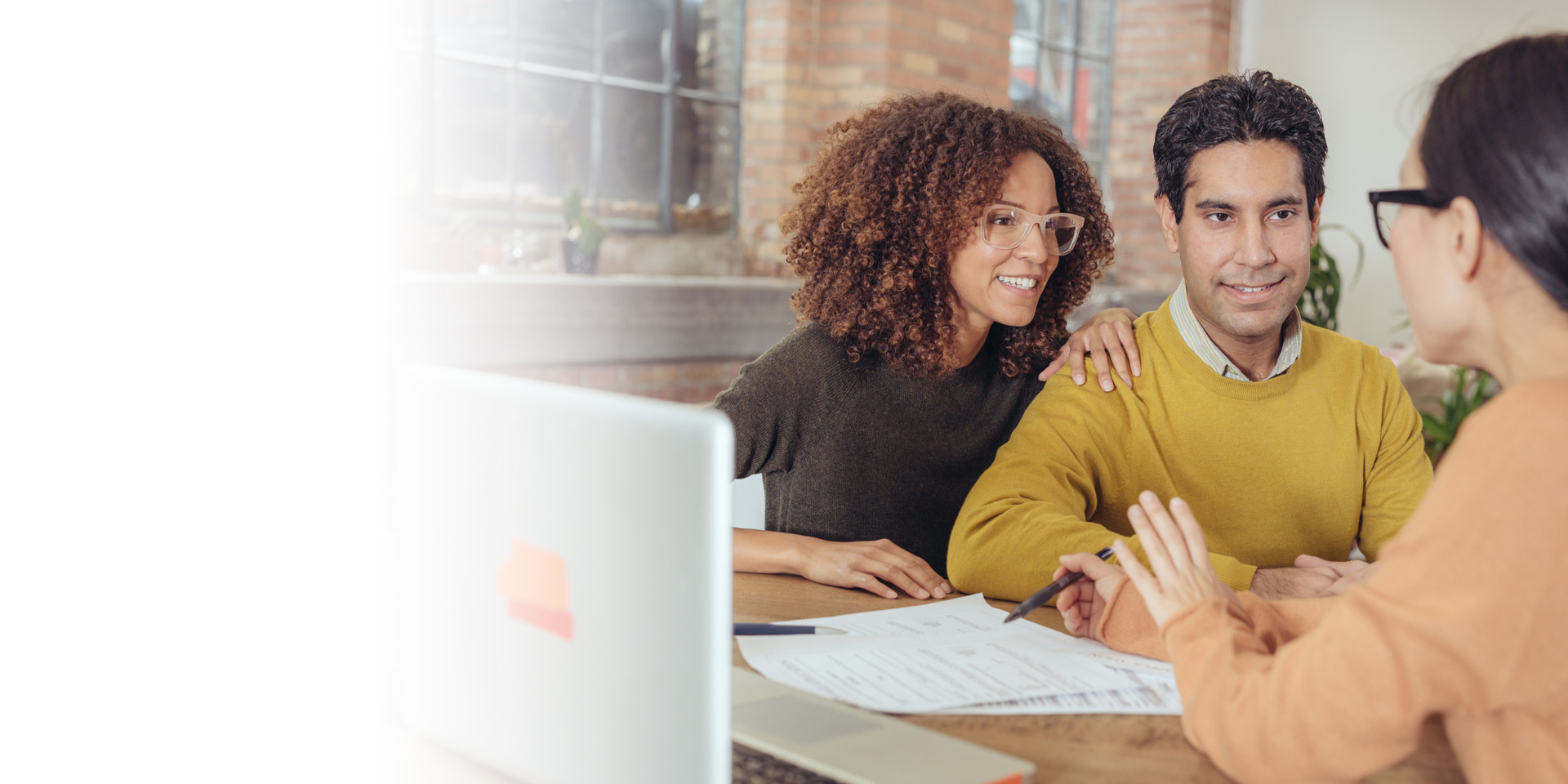 A couple talking to their banker about purchasing a new home