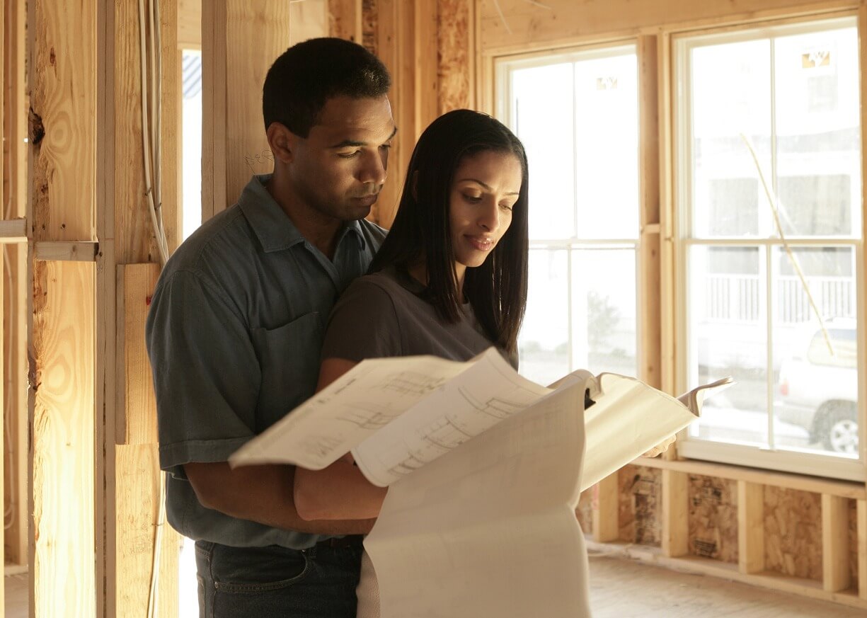 A couple looking at their blue prints of their new home