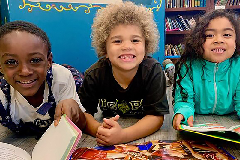 Kids together at their school looking at books