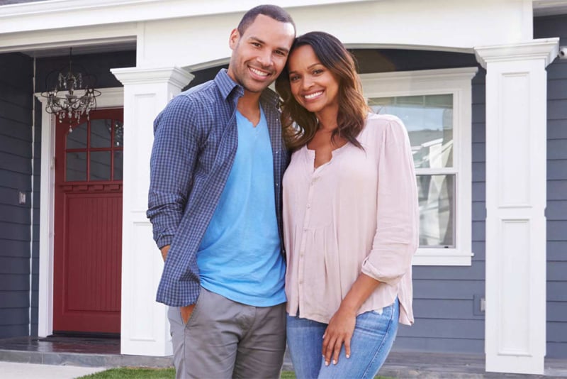 A couple in front of their new home