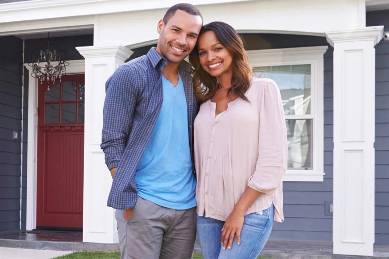 A couple in front of their new home