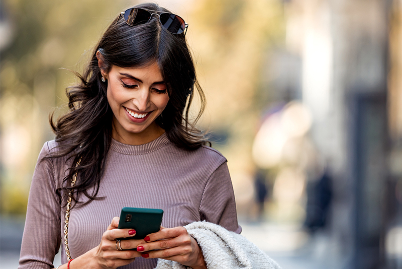 A woman on her phone receiving a text alert