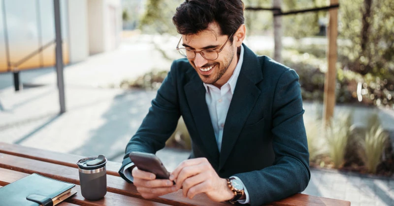 A man looking at his phone and realizing how fast it is to enroll in Zelle