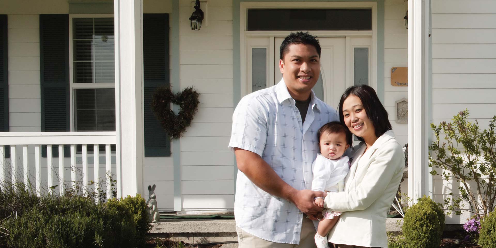 A family outside in front of their new home