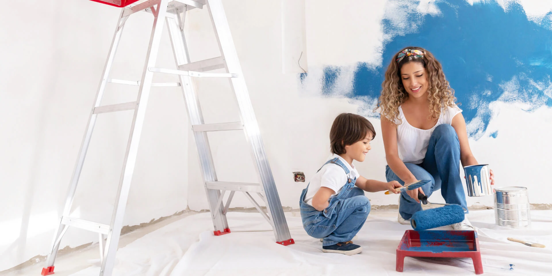 A mom and her son working on painting his new bedroom