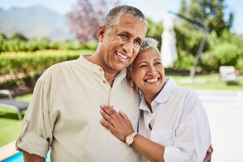 Image of an older couple hugging in their backyard