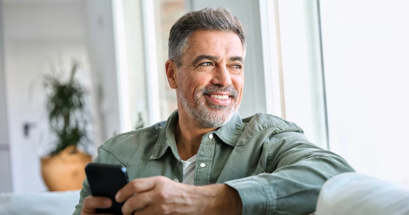 Image of a man sitting on his couch looking out of a window