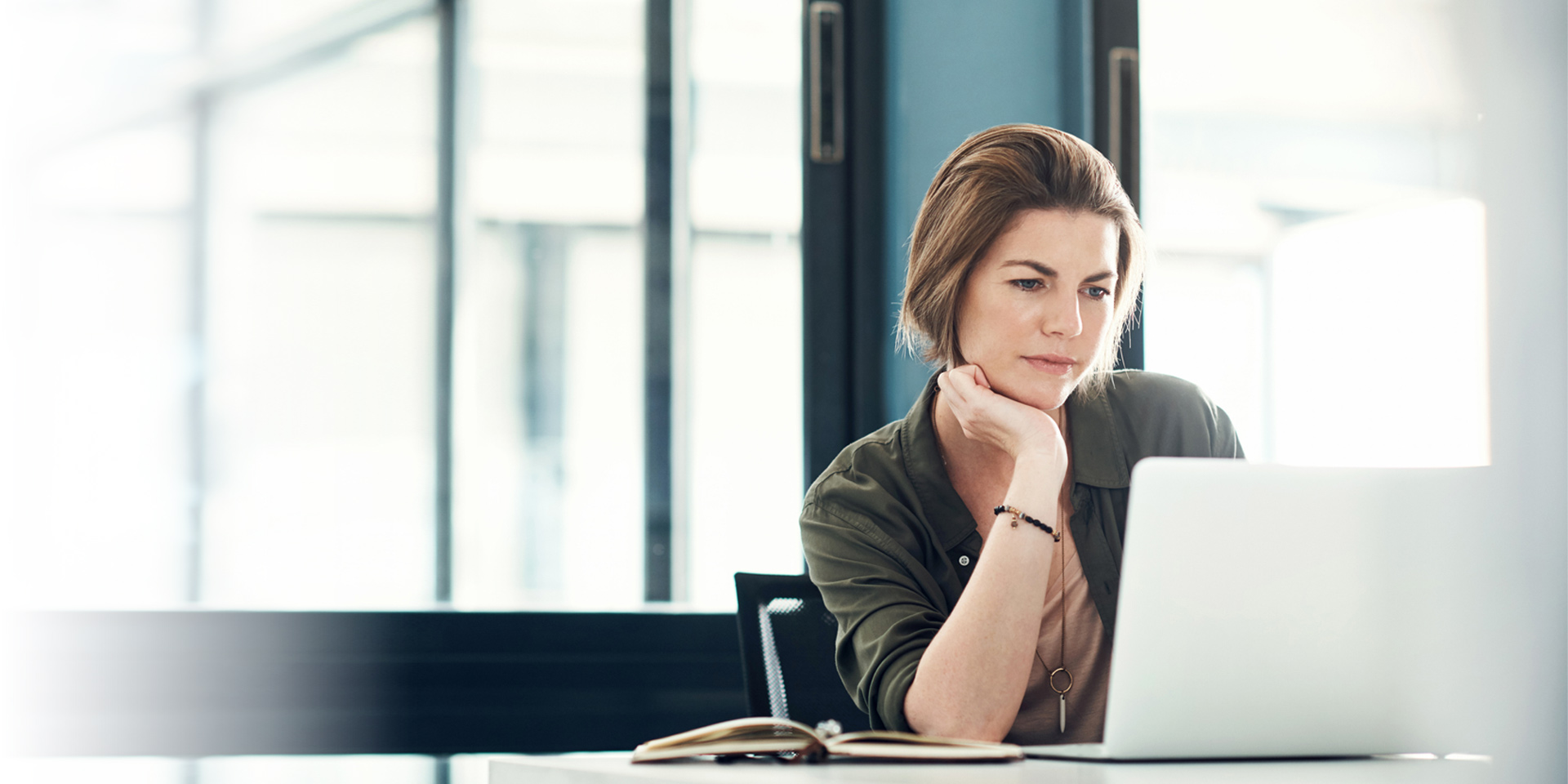 A woman at her laptop watching a video about phishing