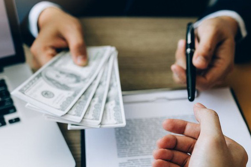 A banker handing his client a pen and money