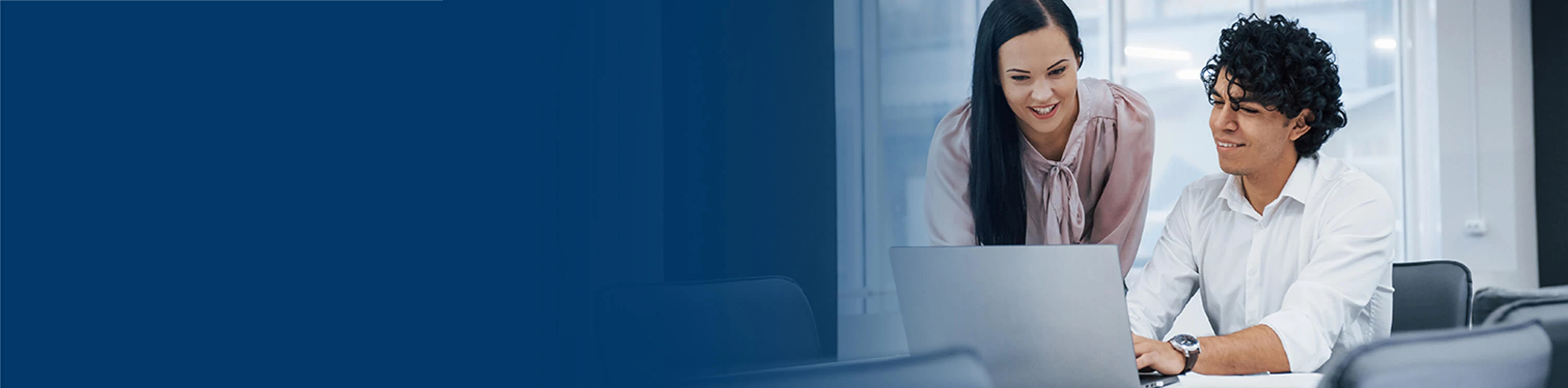Two coworkers looking at a laptop