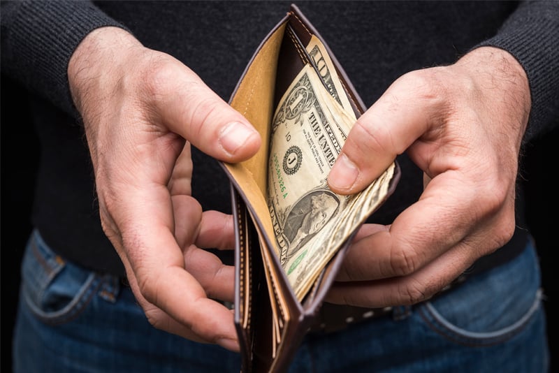 A man looking at the money in his wallet