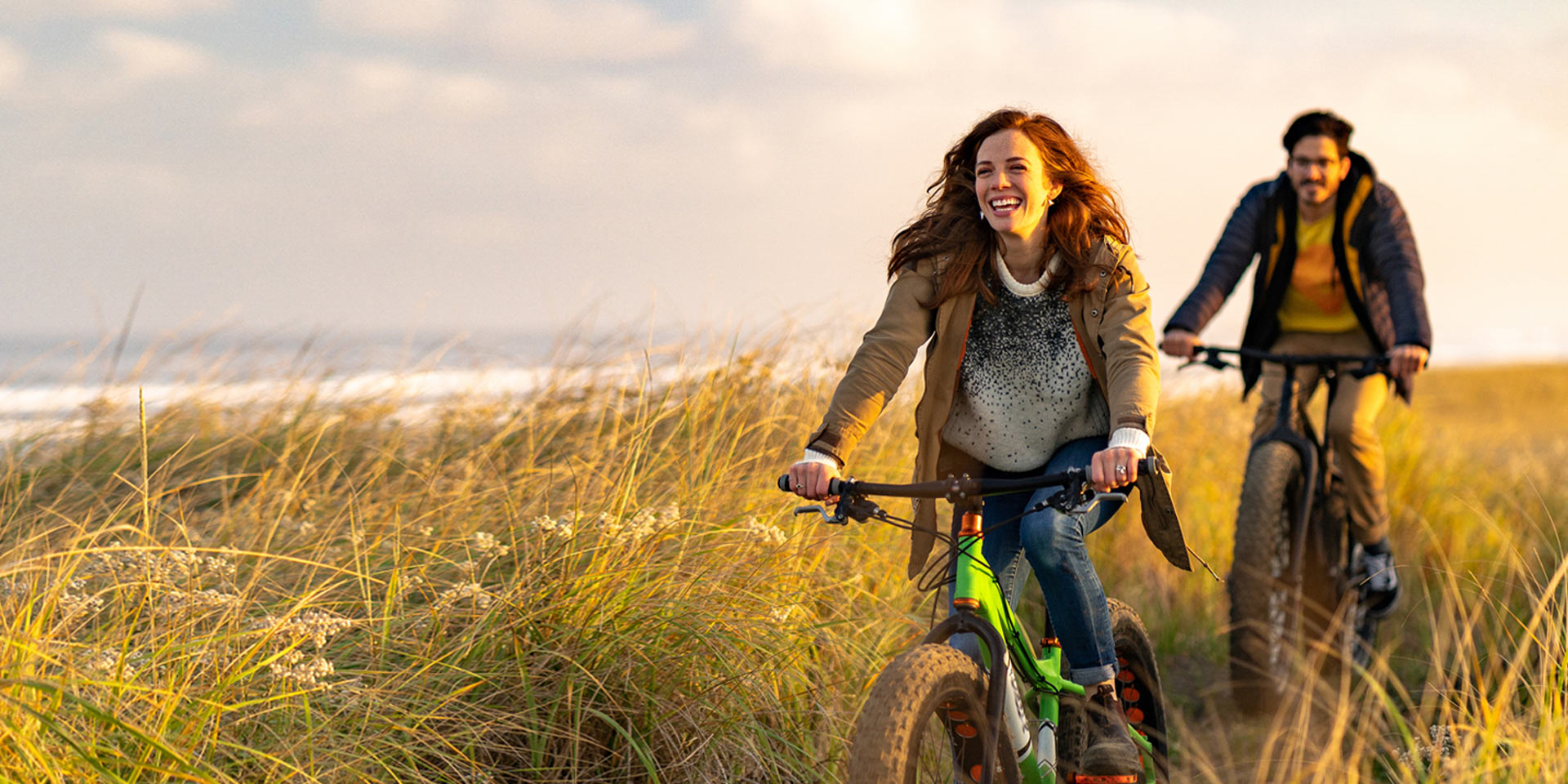 Two people out riding their bikes along the beach