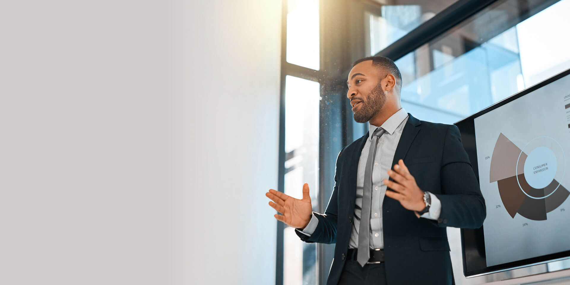 A businessman making a presentation in front of a screen with charts and graphs explains Treasury Management services