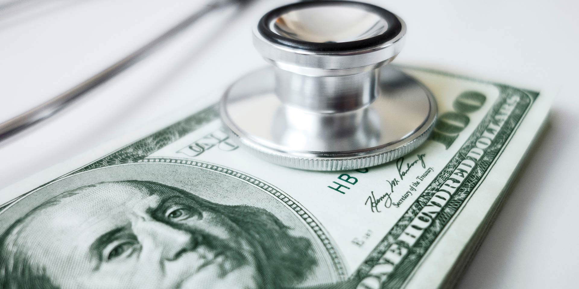A 100-dollar bill next to a stethoscope showing options to save for future goals with a Build-A-Buck Savings account
