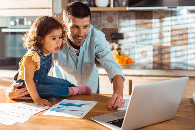 A dad showing his daughter the money in her savings account