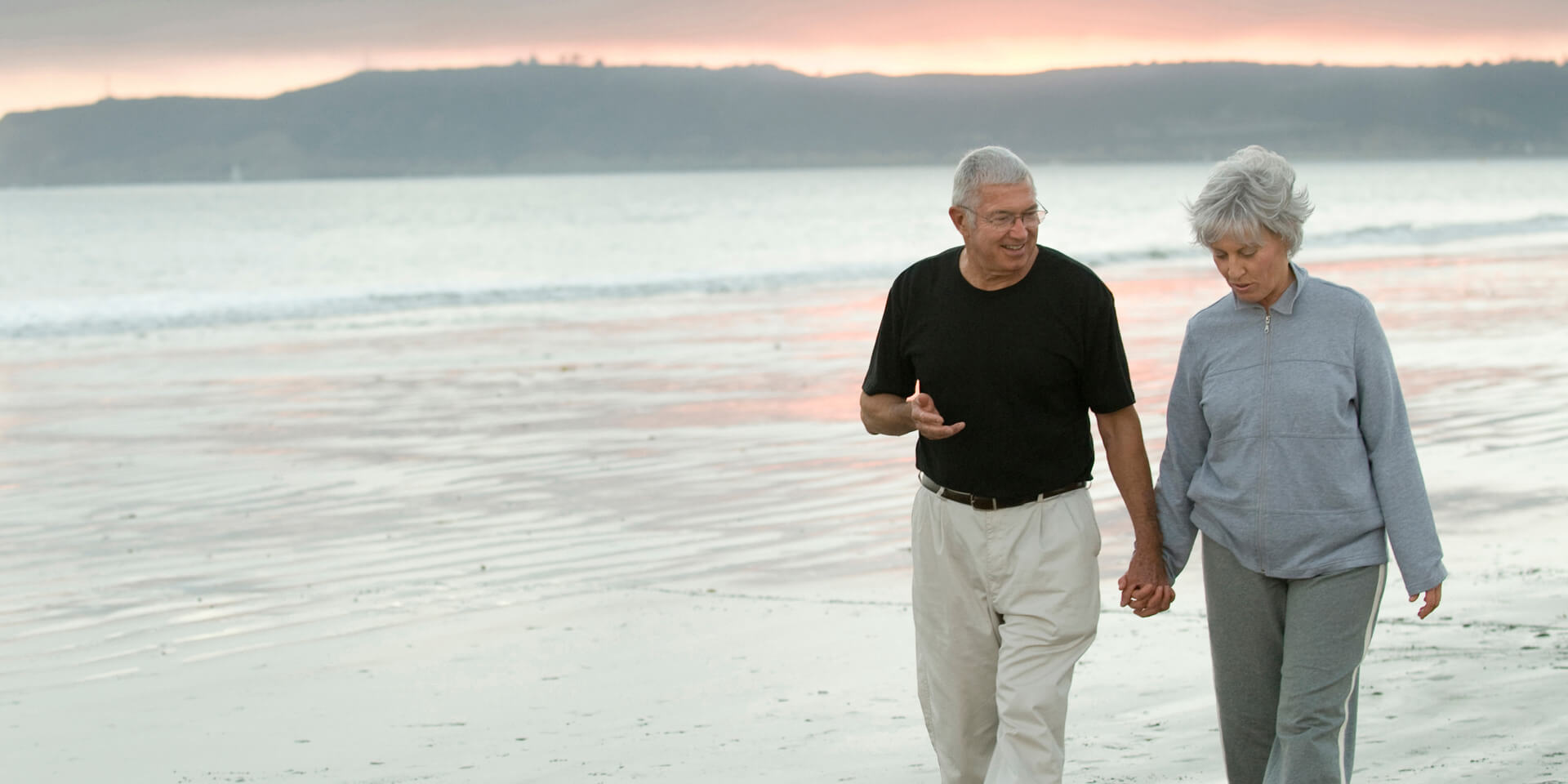 A couple holding hands along the beach