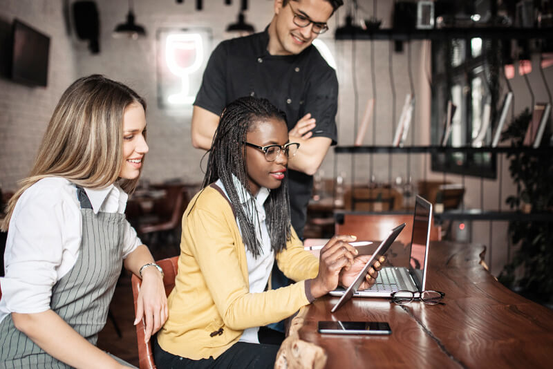 A group of coworkers looking at a tablet device