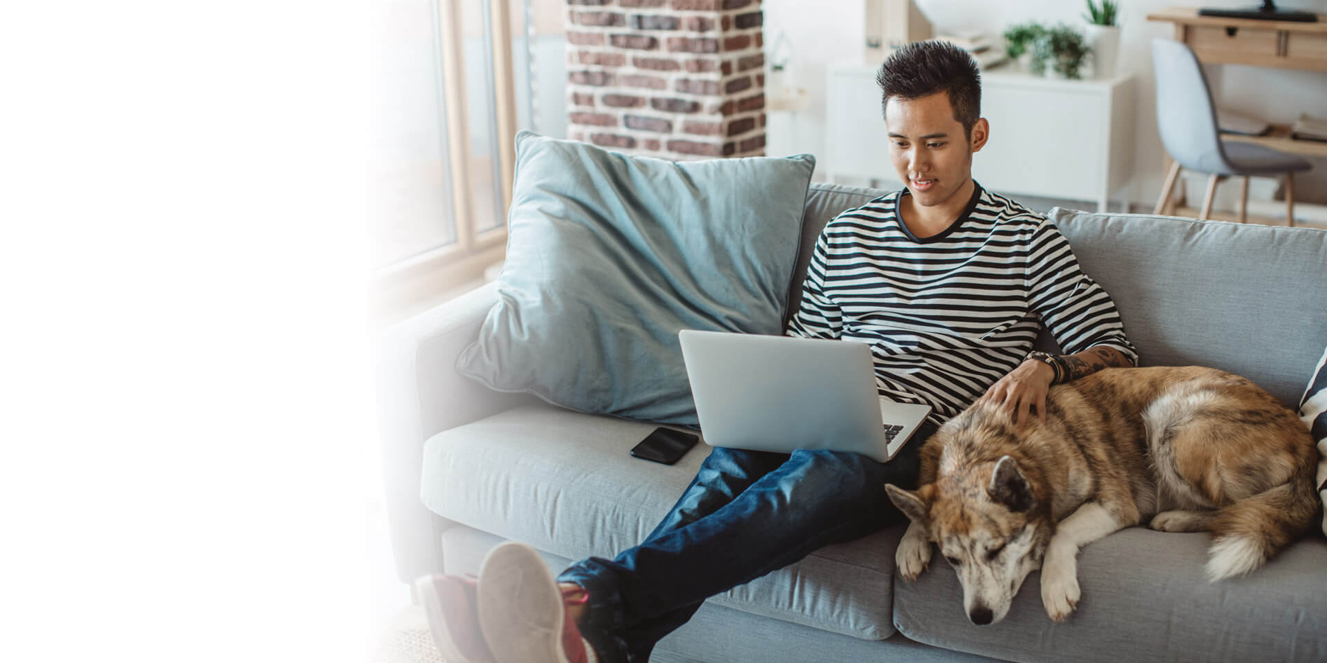 A man sitting on the couch with his dog