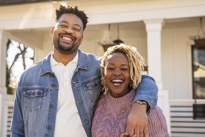 A couple in front of their first home