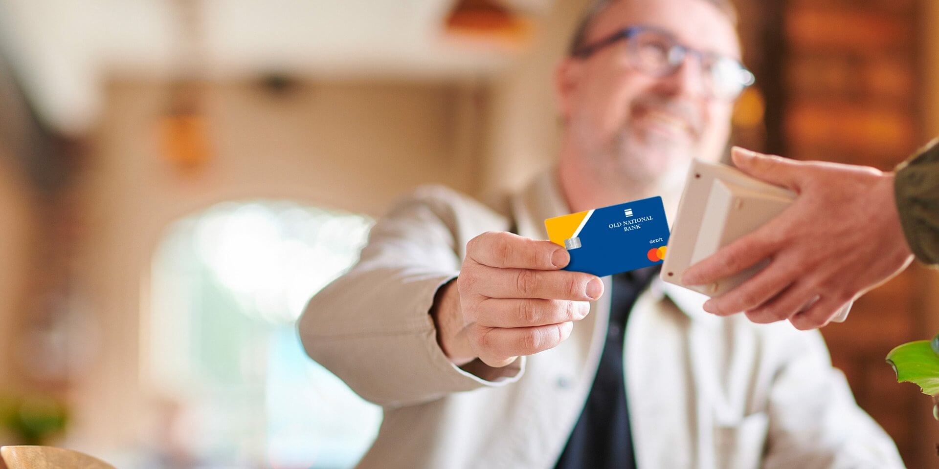 A client using his Old National Bank debit card at a restaurant