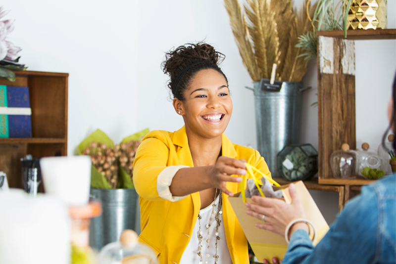 An owner handing her client her purchase
