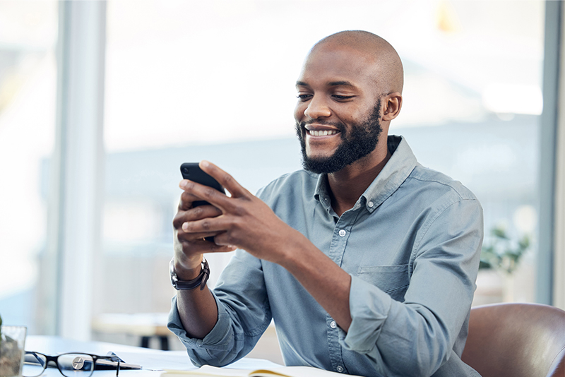 A man on his phone receiving a text alert
