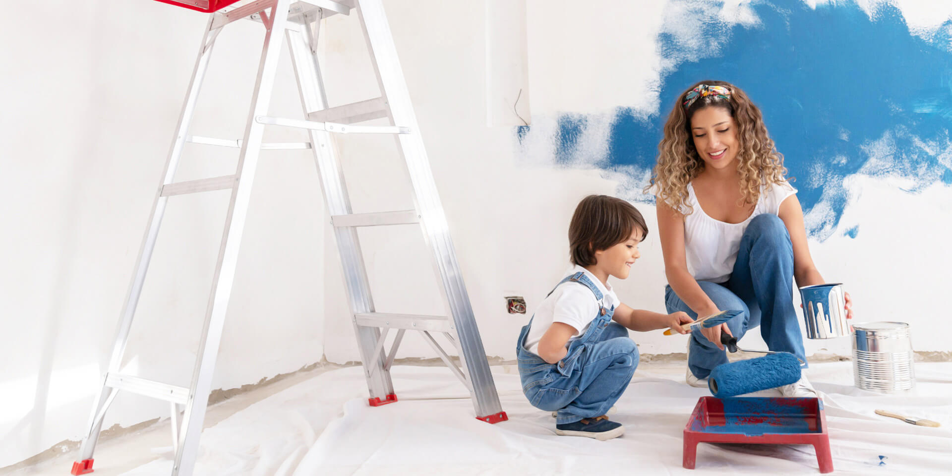 A mom and her son working on painting his new bedroom